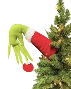 an elf's hand reaching into a christmas tree