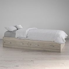 a bed with two drawers underneath it in a room that has white walls and wood floors