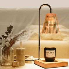 a table lamp sitting on top of a wooden block next to a vase with flowers