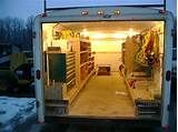 the back end of a truck with its door open and shelves full of items in it