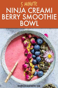 a bowl filled with berries and blueberries next to a spoon