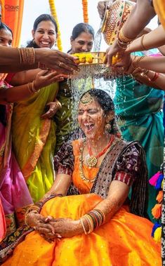 a group of women standing around each other with water on their faces and hands in front of them