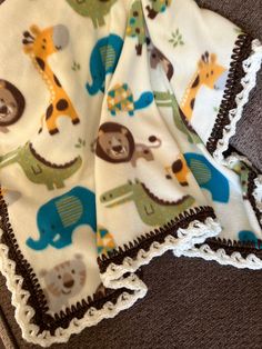 two baby blankets with animals and giraffes on them