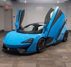 a blue sports car with its doors open