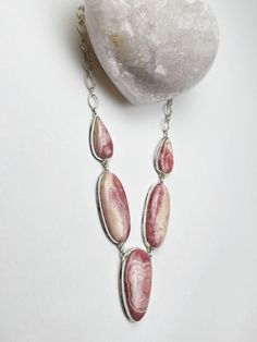 Statement Sterling Silver Rhodochrosite Necklace Rhodochrosite reminds us to love ourselves just as we value our relationship with friends and family. Use Rhodochrosite crystal healing properties to connect the fiery energy of the sacral chakra with the heart. This loving vibration calms the heart and encourages stability when tensions are high. Length: 18 inches adjust to 14 inches Face length: 1 3/4 inches All stone width: 8 inches Rhodochrosite Crystal, Rhodochrosite Necklace, The Sacral Chakra, Larimar Bracelet, Ethiopian Opal Ring, Crystals Healing Properties, Our Relationship, Garnet Pendant, Sacral Chakra