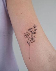 a small flower tattoo on the arm