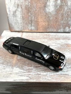 a black toy car sitting on top of a wooden table