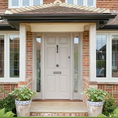 a white front door with two planters on either side