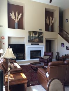 a living room with couches, chairs and a fire place in the middle of it