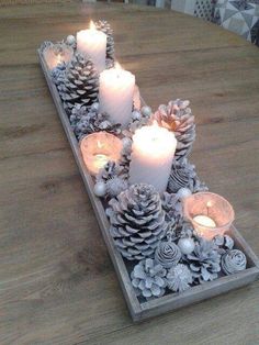 some pine cones and candles are sitting on a table