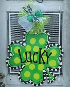 a shamrock door hanger with the word lucky on it