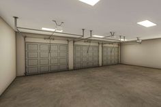 an empty garage with three overhead lights and two doors on the side of the building