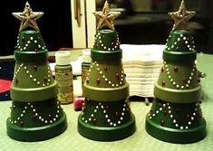 three green christmas trees sitting on top of a table