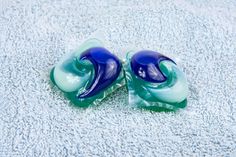 two blue and green glass objects laying on a towel