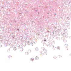 pink and white background with lots of small crystal stones on the bottom right side, as well as some smaller crystals in the middle