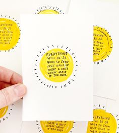 a person holding up some yellow stickers on white paper with words written in them