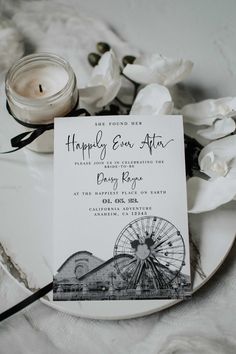 a white plate topped with a card next to a candle