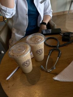 two cups of coffee sitting on top of a table next to a stethoscope