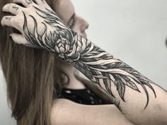 a woman with long hair and tattoos on her arm