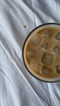 a cup filled with ice sitting on top of a white sheet