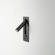 a black handle on a white wall with an electrical outlet in the middle and two wires attached to it