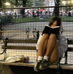 a person sitting on a bench reading a book