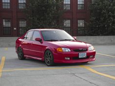 a red car is parked in a parking lot