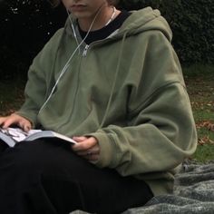 a young man sitting on the ground wearing headphones