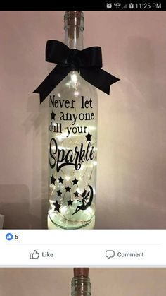 a bottle with some lights on it and a black ribbon around the top that says never let anyone dull your sparkle