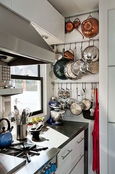 a kitchen with pots and pans hanging on the wall above the stove top oven