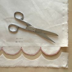 a pair of scissors sitting on top of a piece of fabric