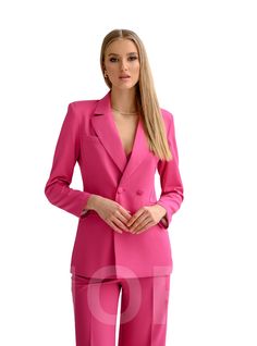 a woman in a pink suit posing for the camera with her hands on her hips