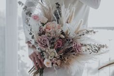 a woman holding a bouquet of flowers in her hands