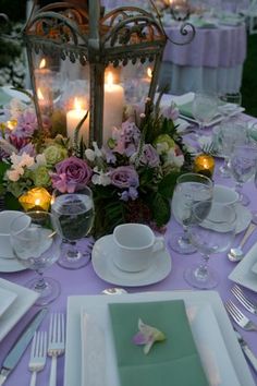 the table is set with plates, silverware and candlelight centerpieces for an elegant dinner