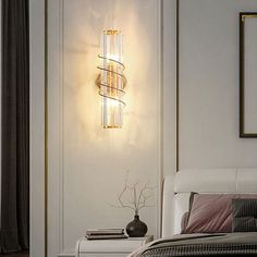 a bed room with a neatly made bed and a wall light