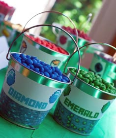 three buckets filled with candy sitting on top of a table