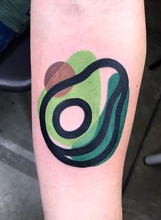 a person with a tattoo on their leg that has a green and black swirl design