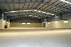 an empty warehouse with no people inside or outside the doors and lights shining on the floor