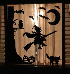 the silhouettes of witches, cats and bats are seen through a window