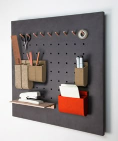 a gray wall mounted with some office supplies on it