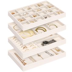 three white drawers filled with jewelry on top of each other