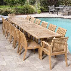 an outdoor dining table and chairs next to a swimming pool in a backyard with stone pavers