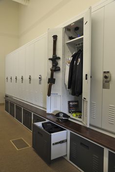 lockers are lined up against the wall with coats hanging on them