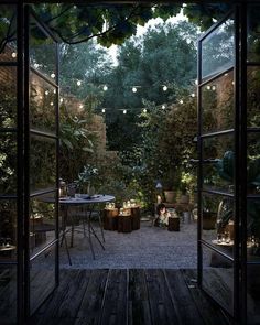 an open door leading into a patio with lights strung from the ceiling and tables in the middle