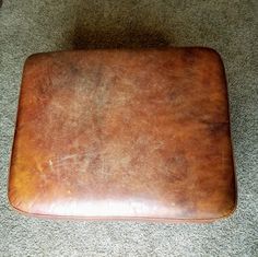 a brown leather cushion sitting on the floor