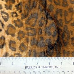 an animal print fabric is shown next to a measuring ruler with the word fabric's & fabrics, inc on it