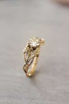 a close up of a gold ring with a flower design on the front and side