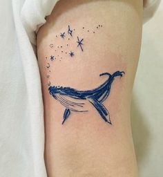 a tattoo on the leg of a woman that has a blue whale in it's stomach