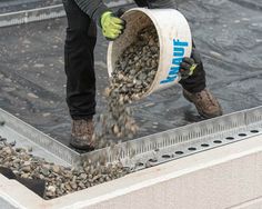 a man is pouring gravel into a bucket on top of a metal grating pan