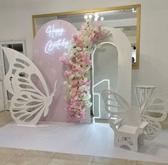 there is a display with flowers and butterflies on the floor in front of a mirror